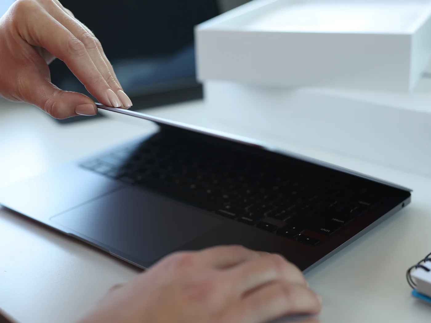 Ein fabrikneuer Laptop wird ausgepackt und zum ersten Mal aufgeklappt